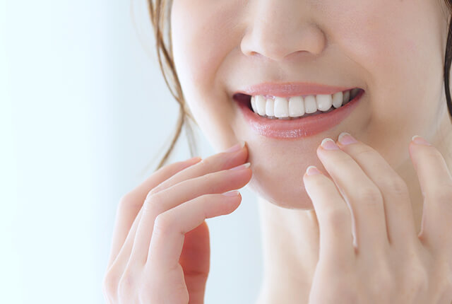 白い歯を見せて微笑む女性